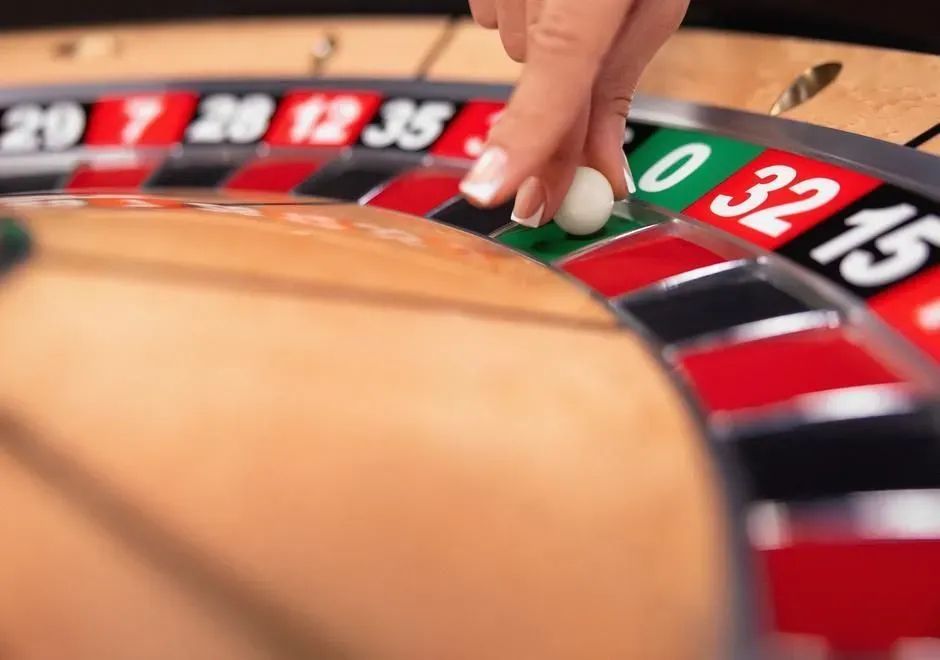 Dealer placing the ball on a live physical roulette wheel